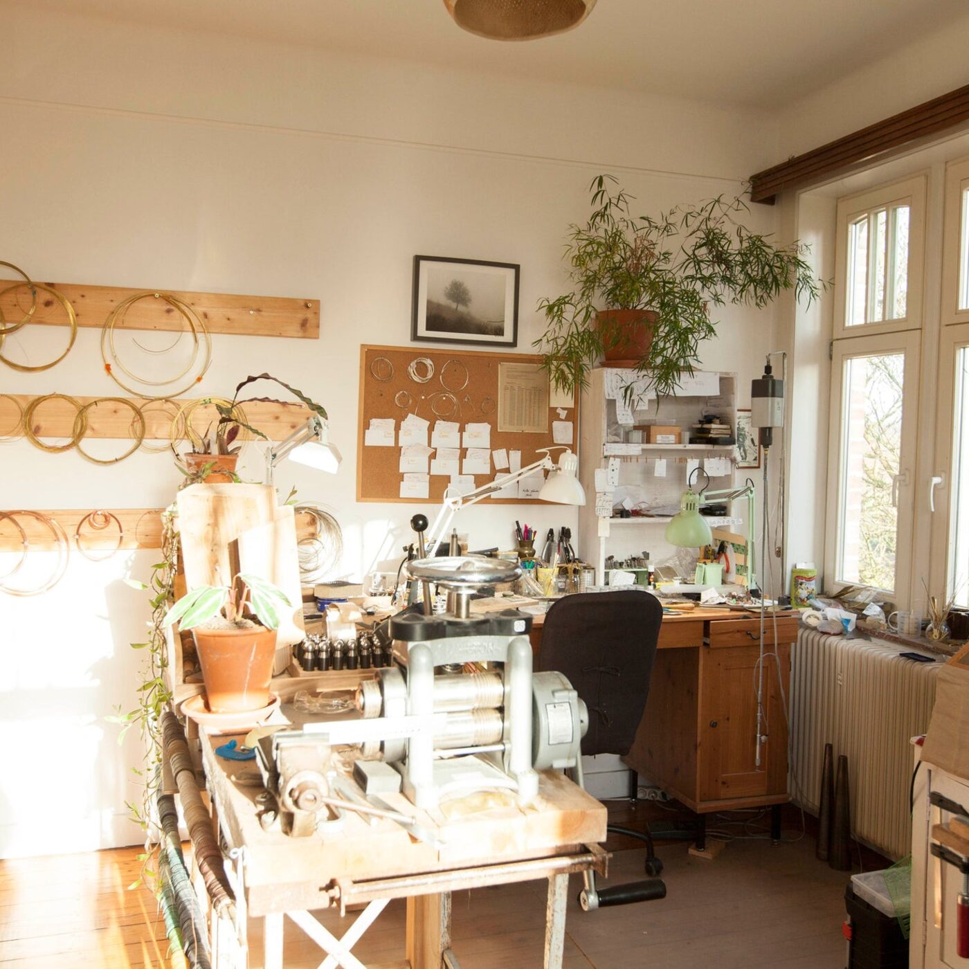 Umya's silversmithing workshop: rolling mill, hand tools and hoops on the wall by the window